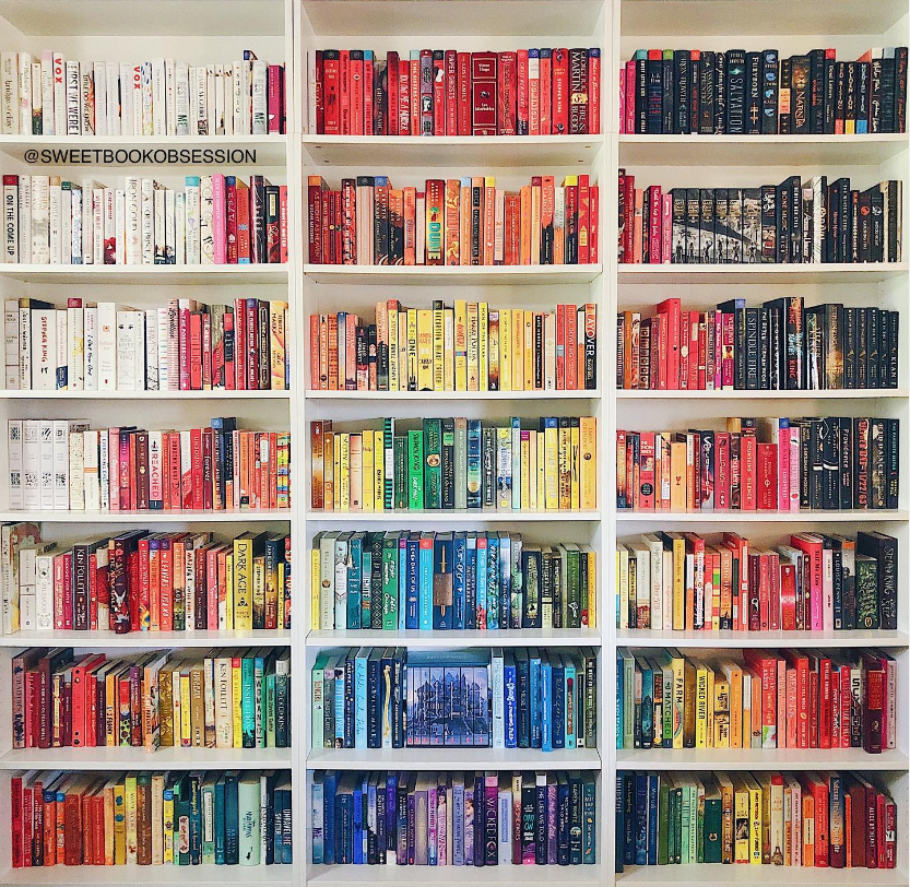 Books organized by color to create a rainbow effect. The colors are in the shape of the rainbow. Home Library Organization. Book Organization